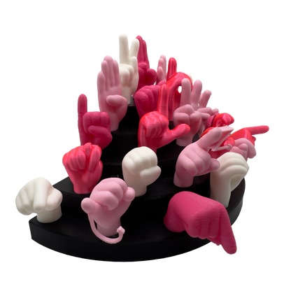 Set of pink, magnet and white hand gesture figures on a black base